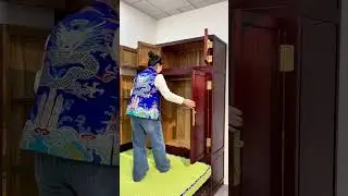 The bed has a green mattress with a blue patterned cover and red pillows.