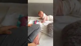 Cute baby laughing at toy whistle.