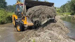 JCB 3DX Machine Building A Dam In A River And Pumping Water
