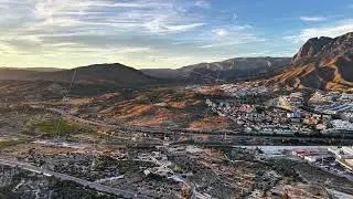 Sunset Drone Scans Rugged Landscape, Drone Captures Valley Scene During Sunset With Distant Peaks