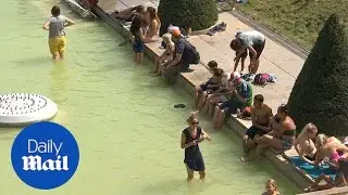Tourists jump in fountains during record heatwave in Paris
