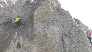The two miners looked for sand on a cliff, while other workers took turns sifting it