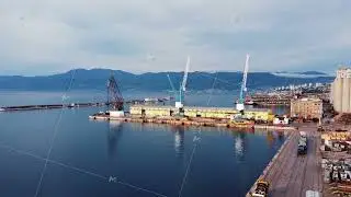 Drone view of the cargo seaport and huge port cranes. Handling dock for ships, dry cargo ships