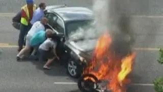Crowd lifts burning car to rescue man