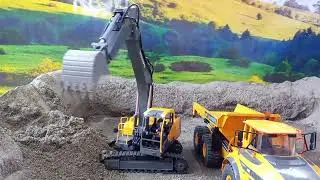 Rc excavator mines sand with rc dump truck at the mine site.