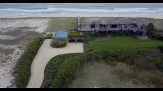 Aerial tracking shot of large oceanfront Hamptons estate