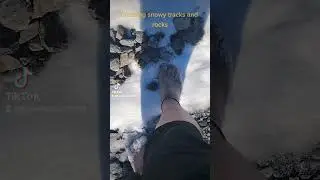 Walking barefoot on some snowy rocks and tracks
