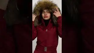 A CHERRY GIRL DANCING IN A BLACK SHINY SKI SUIT WITH A HOOD.