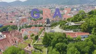 Inscription on video. Graz, Austria. Clock Tower in Graz. The historic city center aerial view. Moun