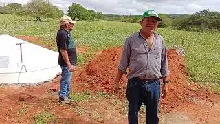 Ze mostra a bento uma cisterna que ganhou do presidente lula.Bento ficou alegre.