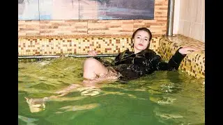 stylish girl in wet clothes in a beautiful pool posing for wetlook video