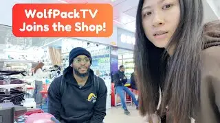 Black American talking With a Chinese Shopkeeper in a Gadget Shop
