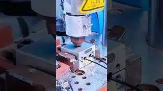 Hands adjust precision jig&mdash;red base anchors metal as wires connect for testing in quiet control.