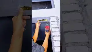 Installing Door Hardware with Power Drill into Frame Beside Brick Wall Construction