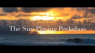 The Sun Peeking Through Clouds Over the Ocean