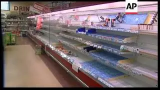 People queueing for radiation screening, shelves cleared of food