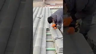 Worker carefully installing roof tiles with precision and safety