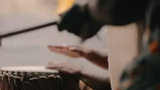 BLURRY VIEW OF MEN DRUMMING ON TRADITIONAL AFRICAN DRUMS 4K