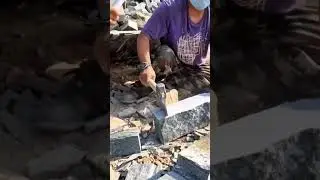 Breaking granite stones manually with hammer