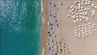 Oludeniz, Turkey. Aerial top down view of crowded Oludeniz Beach with rows of colorful umbrellas,...