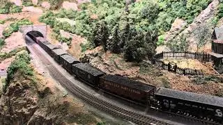 PRR Q2 and medium coal train descend a grade through tunnels at John K's HO layout.