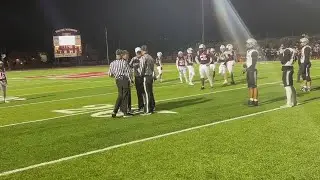 Referees talking and reversing a call from an interception to a completed pass