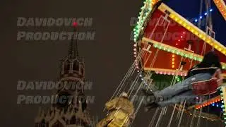Colorful carousel lights illuminating Spasskaya Tower of Moscow Kremlin at night
