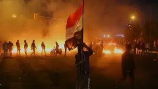 Iraqi anti-government protesters burn tyres and chant slogans in Basra | AFP