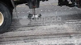 Truck mounted salter applying salt to snowy street stock video. Slow motion. Toronto, Canada. HD.