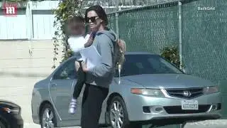Charlize Theron in leggings and sandals carries daughter to car