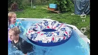 Boy jumping in the pool fully clothed 