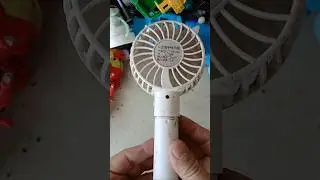 Discovering a working old handheld mini fan while rummaging through a pile of old items.