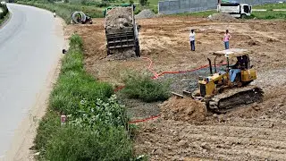 Dump truck pouring soil deleted pit next to the road with Mitsubishi Bulldozer skills