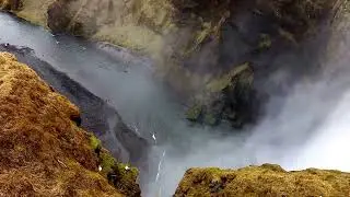 Huge Waterfall falling off a massive moss covered cliff called Sk&oacute;gafoss in Iceland