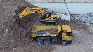 RC machines moving sand. Excavator, trucks and wheel loader team up.