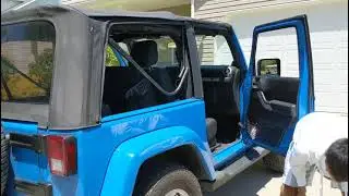 Flipping down the soft top on a 2-door Jeep Wrangler JK (2007-2018)