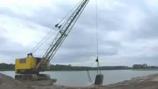 Electric dragline excavator Unex E-303 extracting gravel from water