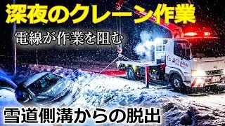 深夜のクレーン作業　雪道側溝からの脱出　電線が作業を阻む