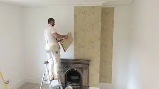 Wallpapering a whole room starting with the chimney breast wall.