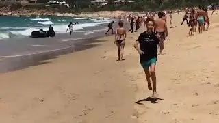Begegnung am Strand: Fl&uuml;chtlingsboot trifft auf Touristen