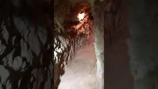 Walking through a tunnel at The Comet opal mine in Koroit