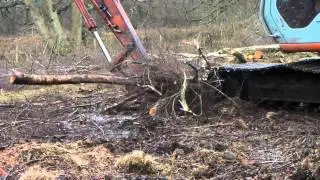 360 Excavator raking up brash piles on Foxlease Meadows SSSI 2012