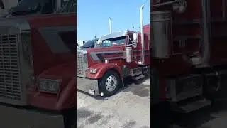 Beautiful cranberry Freightliner classic  rig chrome visor lights above Grey and black side stripes