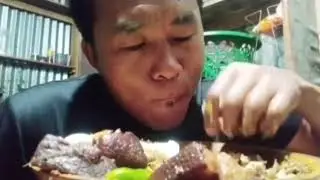 Eating local pork meet with egg and green chilli one piece
