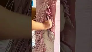 Manually slicing pink paper into decorative strips.