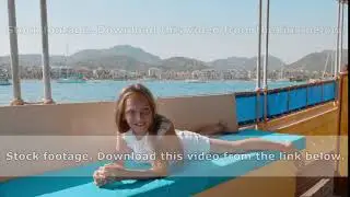 Carefree girl relaxing on couch sailing boat on sea cruise on mountain landscape. Tourist girl lying