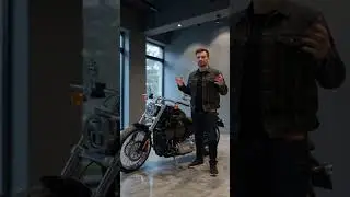 A presenter explains a new motorcycle in a showroom, highlighting engine, design, performance,