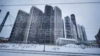 Modern skyscrapers rising above snowy urban landscape viewed from moving train in Moscow
