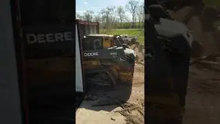 The Beak Skid Steer Attachment - loading logs into shipping container