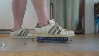 Well worn dirty Adidas Superstars stomp, trample and destroy vintage model train wagon